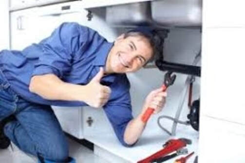 happy plumber under sink  